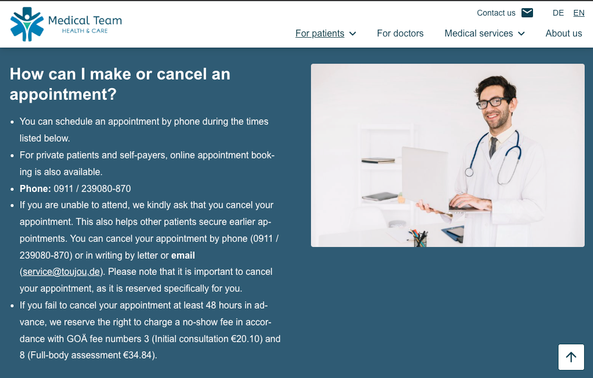 A doctor in a white coat smiles as he holds a laptop in a modern, bright room.