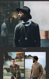 Ein stilvoll gekleideter Mann mit Hut und Brille steht vor einer modernen Wand, während Menschen im Hintergrund vorbeigehen.