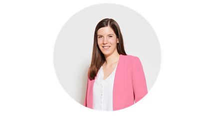 Eine Frau mit langen, braunen Haaren lächelt freundlich in einem rosa Blazer vor einem weißen Hintergrund.