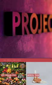 Der Schriftzug 'PROJECT' leuchtet in kräftigen Farben vor einer strukturierten Wand, die eine kreative Atmosphäre schafft.